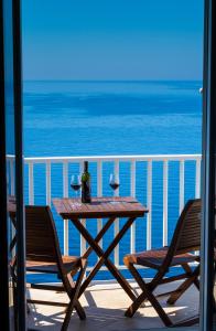 - une table avec deux verres de vin sur le balcon dans l'établissement Apartments Stella Maris, à Cavtat