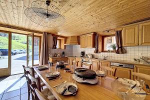 eine Küche mit einem großen Holztisch mit Stühlen in der Unterkunft Résidence Les Granges - Chalet spacieux · Centre village des Granges · Sauna MAE-0184 in Saint-Marcel