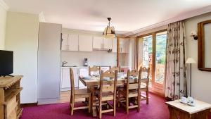 eine Küche und ein Esszimmer mit einem Holztisch und Stühlen in der Unterkunft Résidence Les Cristaux - Appartement rénové · Proche des pistes · Balcon · Sauna · Hammam · WIFI MAE-0304 in Levassaix + 19 Fotos
