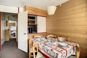 ein Esszimmer mit einem Tisch und Geschirr darauf in der Unterkunft Résidence Soldanelles A - Appartement spacieux · Proche des pistes · Parking inclus MAE-0374 in Les Menuires