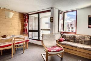 ein Wohnzimmer mit einer Couch, einem Tisch und einem Fenster in der Unterkunft Résidence Soldanelles A - Appartement spacieux · Proche des pistes · Parking inclus MAE-0374 in Les Menuires