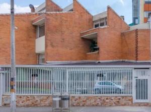 a large brick building with a white fence at Hotel Boutique Radel in Bogotá