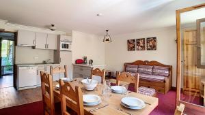 eine Küche und ein Esszimmer mit Tisch und Stühlen in der Unterkunft Résidence Les Cristaux - Appartement spacieux & rénové · Proche des pistes · Balcon · Sauna · Hammam · WIFI MAE-0524 in Levassaix