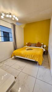スタンにあるMagnifique T2 proche Paris et Stade de Franceのベッドルーム1室(黄色い壁のベッド1台付)