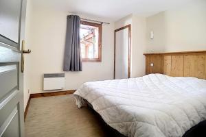 ein Schlafzimmer mit einem weißen Bett und einem Fenster in der Unterkunft Résidence Les Cristaux - Appartement confortable et rénové · Proche des pistes · Balcon · Sauna · Hammam · WIFI MAE-0674 in Levassaix