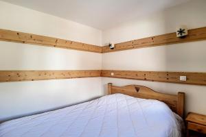 a bedroom with a white bed with wooden walls at Résidence Les Cristaux - Appartement spacieux & rénové · Proche des pistes · Sauna · Hammam · WIFI · Balcon MAE-0534 in Levassaix
