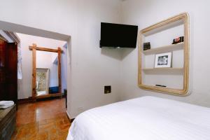a bedroom with a white bed and a mirror at Te Amo Hotel Boutique in San Miguel de Allende
