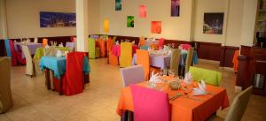 a dining room with colorful tables and chairs at The Golden Truly Hotel & Casino in Paramaribo