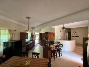 a kitchen and living room with a table and chairs at The Seclusive Mansion in Roseau