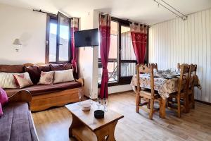 ein Wohnzimmer mit Sofa und Tisch in der Unterkunft Résidence Origanes - Appartement confortable · Départ et retour skis aux pieds · Balcon Parking inclus MAE-1034 in Les Menuires + 13 Fotos
