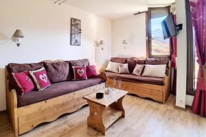 ein Wohnzimmer mit Sofa und Tisch in der Unterkunft Résidence Origanes - Appartement confortable · Départ et retour skis aux pieds · Balcon Parking inclus MAE-1034 in Les Menuires