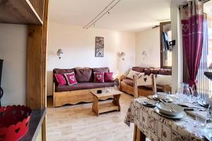 ein Wohnzimmer mit Sofa und Tisch in der Unterkunft Résidence Origanes - Appartement confortable · Départ et retour skis aux pieds · Balcon Parking inclus MAE-1034 in Les Menuires