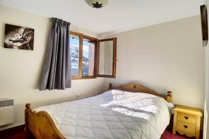 ein Schlafzimmer mit einem Bett und einem Fenster in der Unterkunft Résidence Les Cristaux - Appartement de standing rénové · Proche des pistes · Balcon · Sauna · Hammam · WIFI MAE-1164 in Levassaix