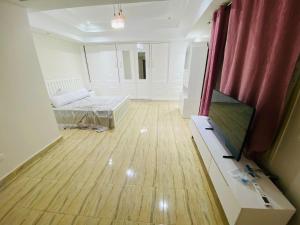 a room with a bed and a television in it at Private Apartment In Villa Zayed in Sheikh Zayed