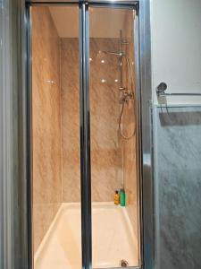a bathroom with a shower and a bath tub at Stunning 5-bed House near NEC & BHX in Solihull +23 photos