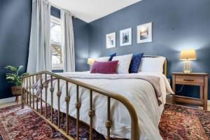 una camera da letto con un letto con pareti blu e una finestra di The Hideaway on Hazel- Luxury Smart Home w Hot Tub ad Ames