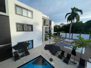 a patio with chairs and umbrellas next to a building at LEVEL suites #8 in Sosúa