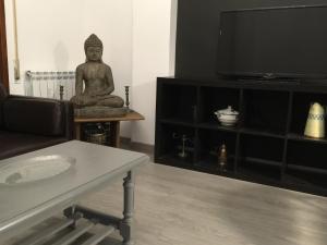 a living room with a statue on a table and a tv at Riojania El Vino in Calahorra