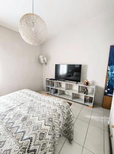 ヴィラ・カルロス・パスにあるCasa Privada Carlos Paz con piscina a dos cuadras del rioのベッドと薄型テレビのある寝室