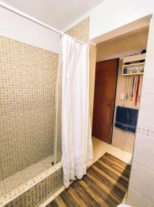 ヴィラ・カルロス・パスにあるCasa Privada Carlos Paz con piscina a dos cuadras del rioのシャワーカーテン付きのシャワー付きバスルーム