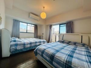 um quarto com duas camas e um lustre em Lucky sky903周围设施配套齐全1Ldk可容纳5人 徒步心斋桥商圈 高楼层俯瞰大阪 em Osaka