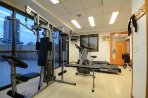 a gym with several tread machines in a room at JK Studio centro, você merece o melhor! in Novo Hamburgo +7 photos