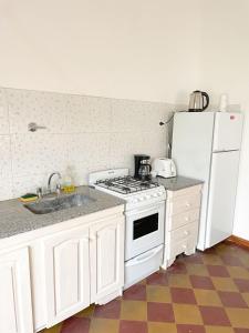 a kitchen with a white stove and a refrigerator at Casa 1936 in Suipacha +22 photos