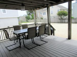 a patio with a table and chairs on a deck at Nicely Renovated First Floor Duplex On The Ocean Side In Brant Beach, in Brant Beach +8 photos