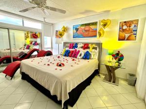 a bedroom with a large bed and two red chairs at Private Apartment at Maré St Clair Hotel in San Juan