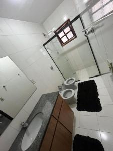 a bathroom with a sink and a toilet and a mirror at Pousada e Restaurante Dona Lu in Itaperuna +44 photos