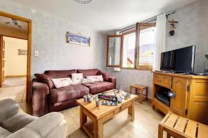 a living room with a couch and a tv at Résidence Saint Marcel - Chalet familial · Centre village de St Marcel · Terrasse ouest MAE-2924 in Saint-Marcel