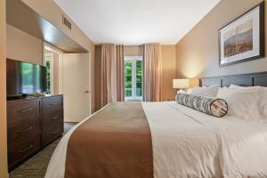 ein Schlafzimmer mit großem Bett und Flachbildfernseher in der Unterkunft King Bed, Balcony, Pool, Hot Tub, Sauna in Edgar + 63 Fotos