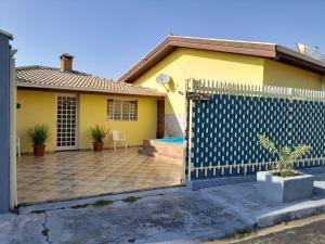 a yellow house with a fence in front of it at Cantinho do Paraíso in Águas de Lindóia