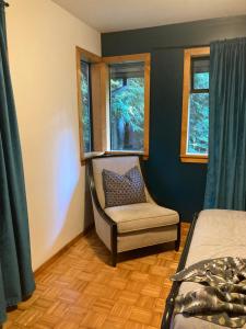 a bedroom with a chair and a window at Hidden Creek Hideaway in Roberts Creek