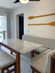a dining room with a table and some wooden utensils at Apartamento pé na areia in Matinhos