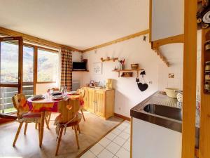 una cucina con un tavolo e sedie in una stanza di Résidence Sarvan - Studio fonctionnel · Au pieds des pistes · Balcon MAE-3204 a Les Menuires