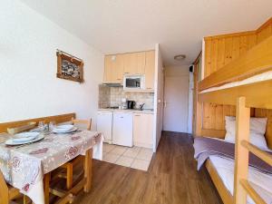 Camera piccola con tavolo e letto a castello. di Résidence Grande Masse - Studio lumineux · Départ et retour skis aux pieds · Balcon MAE-3354 a Les Menuires