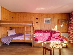 una camera da letto con un letto a castello e un divano di Résidence Grande Masse - Studio lumineux · Départ et retour skis aux pieds · Balcon MAE-3354 a Les Menuires