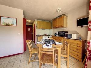 una cucina con tavolo e sedie in una cucina di Résidence Sarvan - Appartement · Balcon · Quartier Preyrand · Pied des pistes MAE-4594 a Les Menuires Altre 5 foto