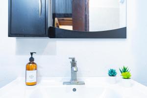 a bottle of soap sitting on a bathroom sink at Sun Love Old San Juan in San Juan +24 photos