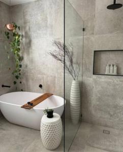 a bathroom with a bath tub and a vase at Kalina Couples Coastal Escape in Blairgowrie +22 photos