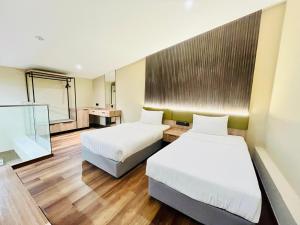 a hotel room with two beds and a mirror at I-VISTA HOTEL in Tawau