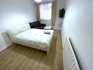 a small living room with a bed and a couch at Laret Guest House in London