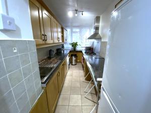 a large kitchen with wooden cabinets and a sink at Laret Guest House in London +13 photos