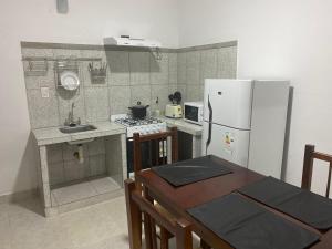 a small kitchen with a white refrigerator and a table at Departamentos Ohana in San Ramón de la Nueva Orán