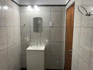 a bathroom with a white sink and a mirror at Departamentos Ohana in San Ramón de la Nueva Orán