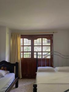 a bedroom with two beds and a large window at Hotel Villa Mary Apartaestudios playa in Puerto Colombia