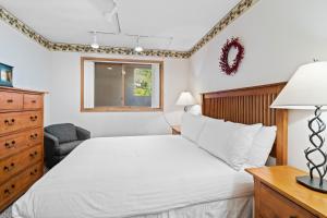 ディロンにあるEast Bay Condos 111の白いベッドとドレッサーのある寝室