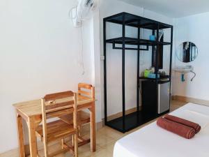 ランタ島にあるBaan phuwaminのデスク、テーブル、椅子が備わる客室です。 +57枚の写真