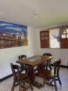 a dining room with a wooden table and chairs at Hotel Villa Mary Apartaestudios playa in Puerto Colombia